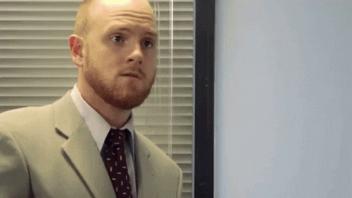 Man In Suit And Tie In Front Of Blinds GIF
