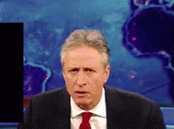 A Man In A Suit And Tie Is Standing In Front Of A World Map GIF