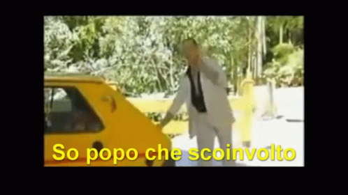 A Man In A Suit And Tie Is Standing In Front Of A Yellow Car With The Words So Popo Che Sconvolto Written In Yellow GIF