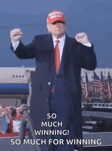 A Man In A Suit And Tie Is Standing In Front Of An Airplane . GIF
