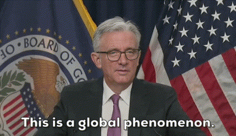 A Man In A Suit And Tie Is Standing In Front Of An American Flag And Says This Is A Global Phenomenon GIF