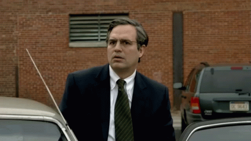 A Man In A Suit And Tie Is Standing Next To A Jeep Wrangler GIF