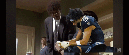 A Man In A Suit And Tie Is Standing Next To A Man In A Blue Jersey With The Number 21 On It GIF