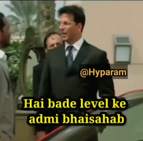 A Man In A Suit And Tie Is Standing Next To Another Man And Says Hai Bade Level Ke Admibhaisahab GIF
