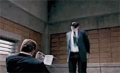 A Man In A Suit And Tie Is Standing Next To Another Man . GIF