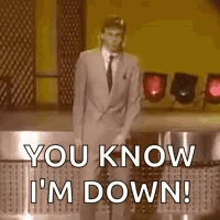 A Man In A Suit And Tie Is Standing On A Stage . GIF