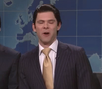 A Man In A Suit And Tie Is Standing With His Eyes Closed . GIF