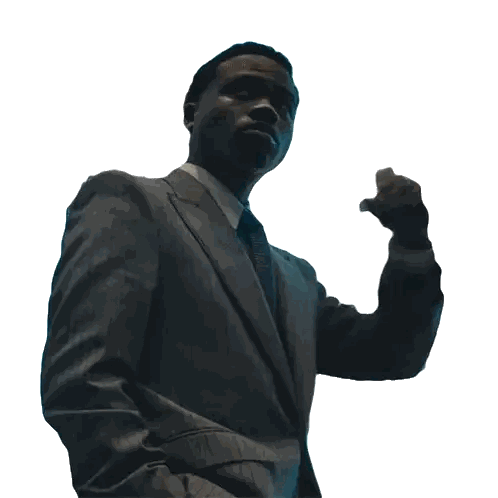 a man in a suit and tie is standing with his fist in the air