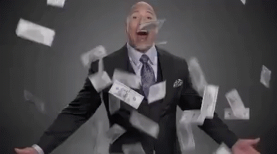A Man In A Suit And Tie Is Surrounded By Money Falling Around Him . GIF