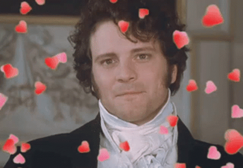 A Man In A Suit And Tie Is Surrounded By Red Hearts GIF
