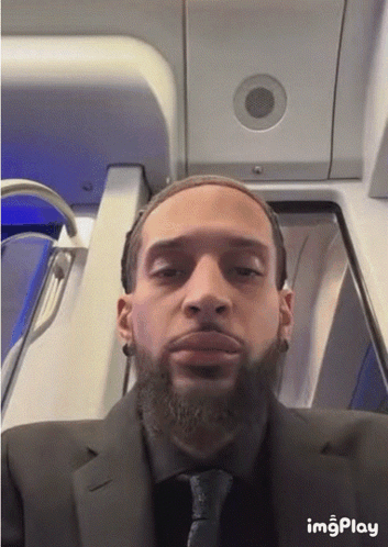 A Man In A Suit And Tie Is Taking A Selfie With Imgplay Written On The Bottom GIF