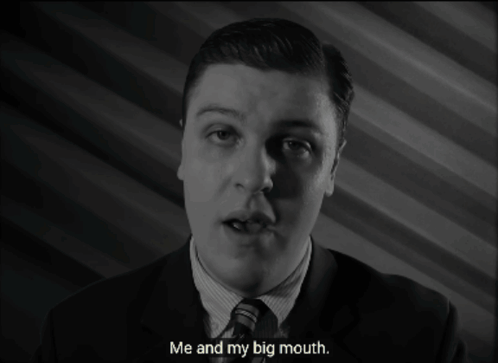 a man in a suit and tie is talking about his big mouth
