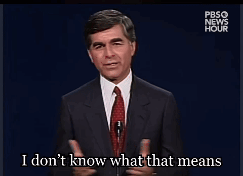 A Man In A Suit And Tie Is Talking Into A Microphone And Says I Don T Know What That Means GIF