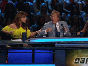 A Man In A Suit And Tie Is Talking Into A Microphone GIF