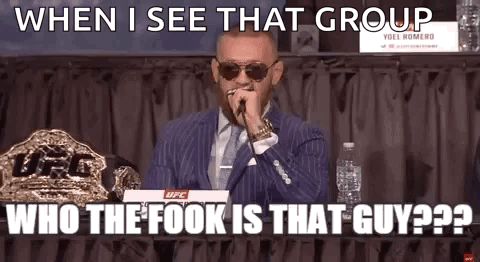 A Man In A Suit And Tie Is Talking Into A Microphone While Sitting At A Table . GIF