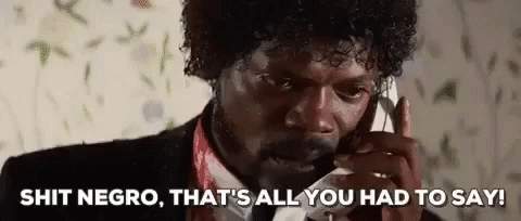 A Man In A Suit And Tie Is Talking On A Cell Phone And Making A Funny Face . GIF