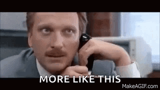 A Man In A Suit And Tie Is Talking On A Cell Phone And Saying `` More Like This '' . GIF
