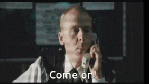 A Man In A Suit And Tie Is Talking On A Cell Phone And Says Come On . GIF