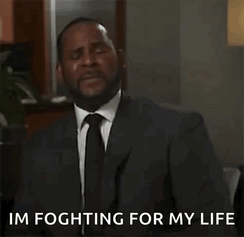A Man In A Suit And Tie Is Talking On A Cell Phone While Dancing . GIF