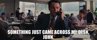 A Man In A Suit And Tie Is Talking On A Cell Phone With The Words Something Just Came Across My Desk John Below Him GIF