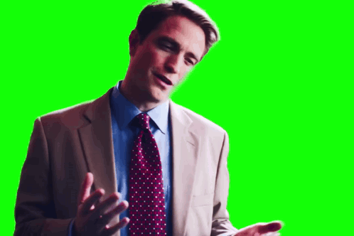 A Man In A Suit And Tie Is Talking On A Green Screen . GIF