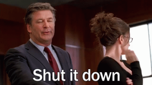 A Man In A Suit And Tie Is Talking To A Woman In A Black Dress . GIF