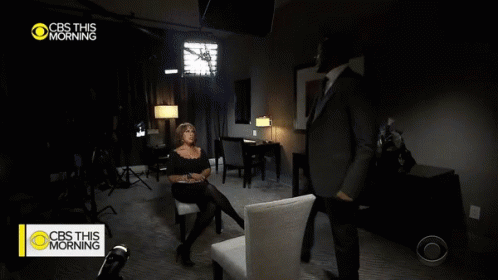 A Man In A Suit And Tie Is Talking To A Woman In A Chair On Cbs This Morning GIF