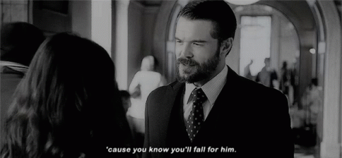 A Man In A Suit And Tie Is Talking To A Woman In A Hallway In A Black And White Photo . GIF