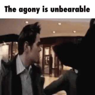 A Man In A Suit And Tie Is Talking To A Woman In A Store . GIF