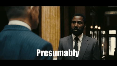 A Man In A Suit And Tie Is Talking To Another Man And The Words Presumably Are Visible GIF