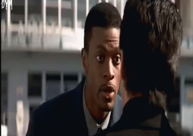 a man in a suit and tie is talking to another man in a black suit