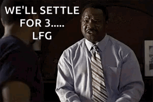 A Man In A Suit And Tie Is Talking To Another Man In A Dark Room . GIF