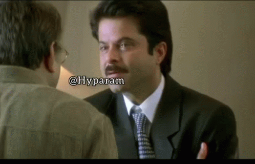 A Man In A Suit And Tie Is Talking To Another Man With A Caption That Says Hyparam GIF