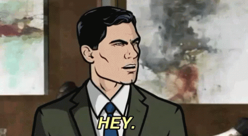 A Man In A Suit And Tie Is Talking To Someone And Saying Hey . GIF
