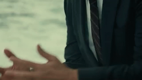 A Man In A Suit And Tie Is Talking To Someone . GIF