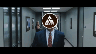 a man in a suit and tie is walking down a hallway with the word unity on his face