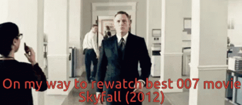 A Man In A Suit And Tie Is Walking Down A Hallway With The Words On My Way To Rewatch Best 007 Movie Skyfall 2012 GIF