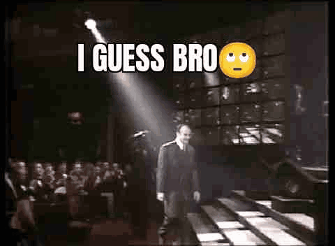 A Man In A Suit And Tie Is Walking Down A Staircase In Front Of A Crowd Of People . GIF