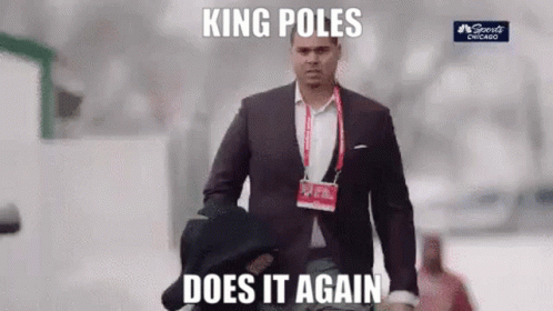 A Man In A Suit And Tie Is Walking Down The Street With A Hat On His Shoulder . GIF