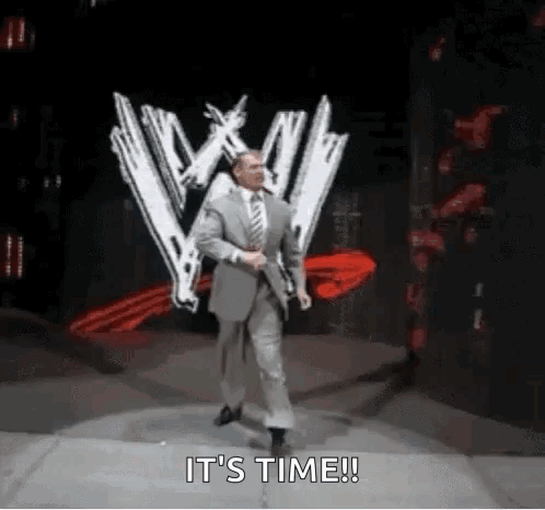 A Man In A Suit And Tie Is Walking On A Stage With The Words `` It 'S Time '' . GIF