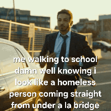 A Man In A Suit And Tie Is Walking To School And Talking About A Homeless Person Coming Straight From Under A La Bridge GIF