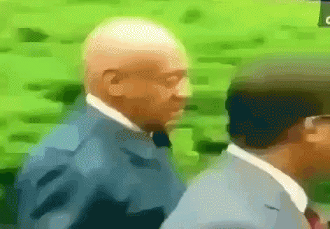 a man in a suit and tie is walking with another man