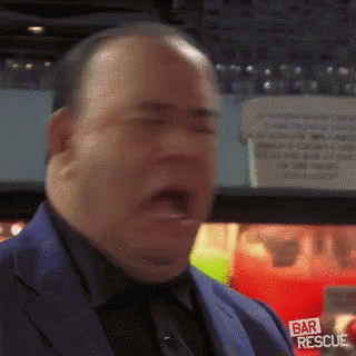 a man in a suit and tie is wearing a bar rescue patch on his chest .