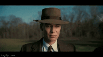 A Man In A Suit And Tie Is Wearing A Hat . GIF