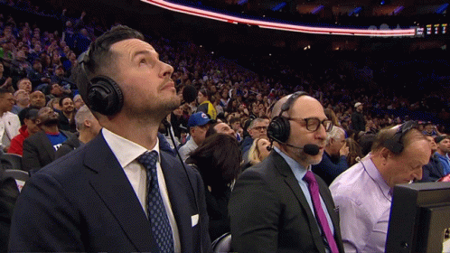 A Man In A Suit And Tie Is Wearing A Headset GIF