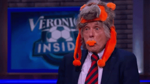 a man in a suit and tie is wearing a stuffed animal hat