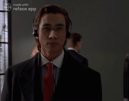 A Man In A Suit And Tie Is Wearing Headphones And A Reface App Logo GIF