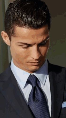 A Man In A Suit And Tie Looks Down GIF