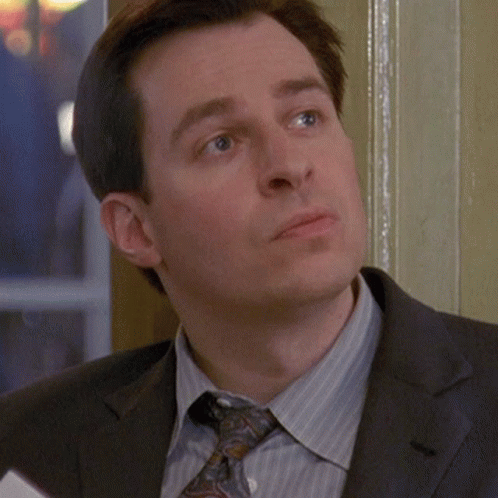 A Man In A Suit And Tie Looks Serious GIF