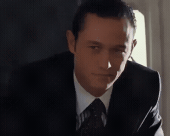 A Man In A Suit And Tie Looks To The Side GIF